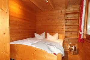 ein Schlafzimmer mit einem Bett in einer Holzhütte in der Unterkunft Blockhaus Säuling - Haus Elise Apartments in Füssen