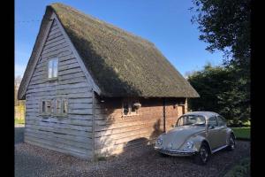 a small house with a car parked in front of it at Yew Tree Barn in Prees