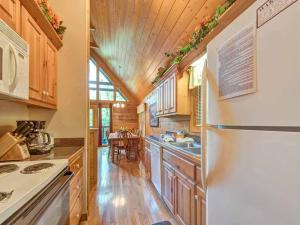 a kitchen with a white refrigerator and wooden cabinets at Idle Days, 2 Bedrooms, Sleeps 8, Pool Table, Grill, Pool Access, WiFi in Gatlinburg