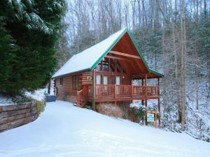 a log cabin in the woods in the snow at Idle Days, 2 Bedrooms, Sleeps 8, Pool Table, Grill, Pool Access, WiFi in Gatlinburg
