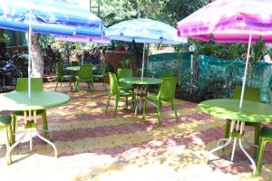 a group of tables and chairs with umbrellas at Neuaura Stays in Mahabaleshwar