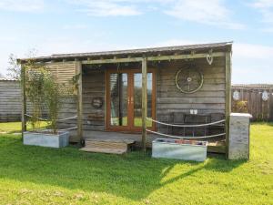 une petite cabane en bois dans un champ d'herbe dans l'établissement The Cabin, à Bude