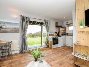 a kitchen with a large window and a table at The Cabin in Bude