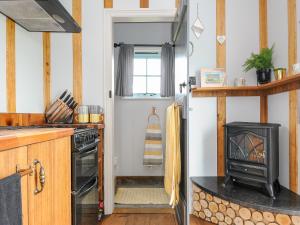 a kitchen with a stove and a stove top oven at Elsie's Hut in Bude