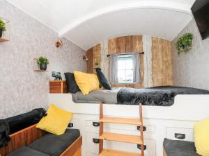 a small room with two bunk beds and a couch at Elsie's Hut in Bude