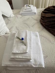 two white towels on a bed with a flower on them at Quinta do Carvalheiro in Sobral de Monte Agraço