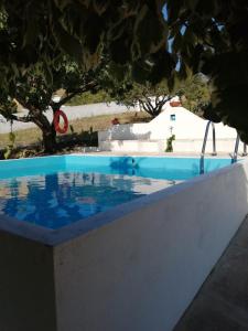 una piscina en un patio con árboles en el fondo en Quinta do Carvalheiro en Sobral de Monte Agraço