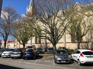 a bunch of cars parked in a parking lot in front of a building at T2 meublé pour curistes, vacanciers et stagiaires in Rochefort +1 photo