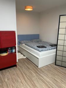 a small bedroom with a bed and a red cabinet at #4 modern & comfortable apartment in Memmingen