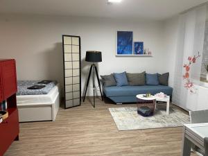 a living room with a blue couch and a bed at #4 modern & comfortable apartment in Memmingen