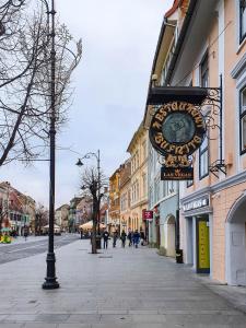 a street with a clock on the side of a building at Studio Bufnița - The Owl's Nest in Sibiu