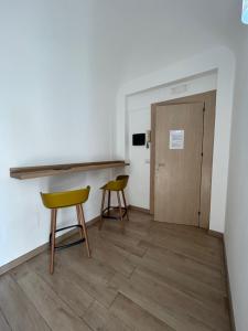 a room with two chairs and a table and a door at Kefa Holiday - Balcone sul Mare in Cefalù
