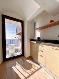 a kitchen with a large window with a view of the ocean at Kefa Holiday - Balcone sul Mare in Cefalù