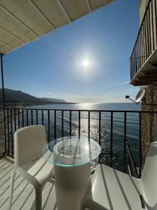a table and chairs on a balcony with a view of the ocean at Kefa Holiday - Balcone sul Mare in Cefalù