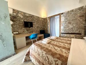 a hotel room with a bed and a desk at Kefa Holiday - Balcone sul Mare in Cefalù
