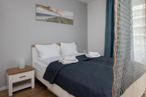 a bedroom with a bed with two towels on it at FALE BAŁTYKU in Gdańsk
