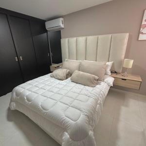 um quarto com uma grande cama branca e 2 almofadas em Apartamento Amoblado Luxury Excelente Ubicacion em Cúcuta