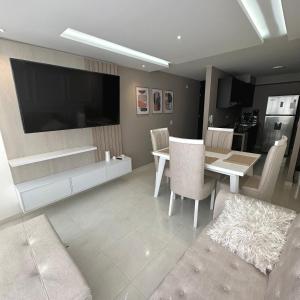 uma sala de estar com uma televisão e uma mesa e cadeiras em Apartamento Amoblado Luxury Excelente Ubicacion em Cúcuta