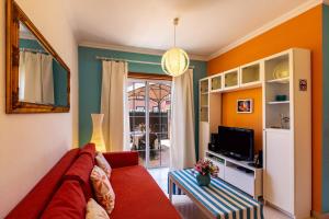 un soggiorno con un divano rosso e una TV di Casa Vacacional Golfin ad Arona