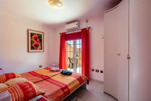 una camera da letto con un letto e una finestra con tende rosse di Casa Vacacional Golfin ad Arona