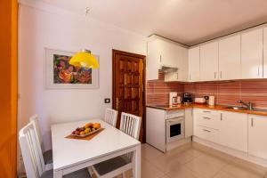 una cucina con un tavolo con una ciotola di frutta sopra di Casa Vacacional Golfin ad Arona