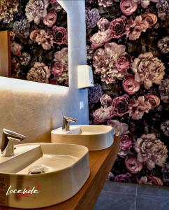 baño con lavabo y papel pintado con motivos florales en Locanda Rossa, en Romans di Varmo