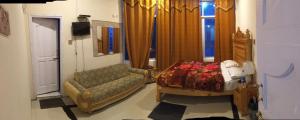Malam Jabba的住宿－Three star Hotel & Rest，带沙发和床的客厅以及窗户。