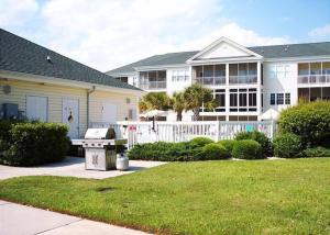 a house with a grill in front of a yard at NEW! Gated Community, Pools, Gym, Beach @ Ocean Keyes #1721 in Myrtle Beach