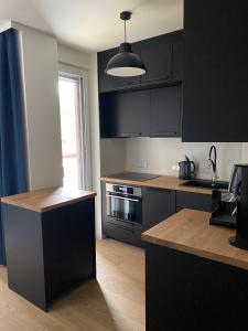 a kitchen with black cabinets and a counter top at See & You Ferienwohnung mit Hotelanbindung in Pörtschach am Wörthersee