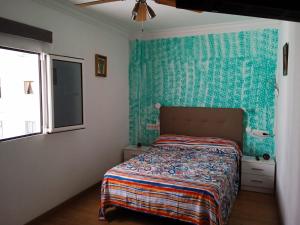 ラスパルマス・デ・グランカナリアにあるApartamento Chabelaの緑の壁、ベッド付きのベッドルーム1室