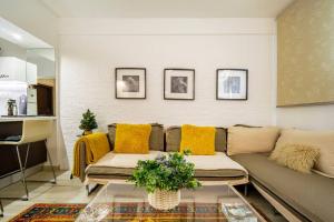 een woonkamer met een bank en gele kussens bij The excellent home in Athene