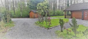 a home with a garden and a wooden cabin at gitelecalibou in Érezée