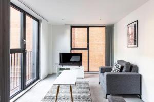 a living room with a couch and a tv at BOLD Apartments - Liverpool City Centre in Liverpool