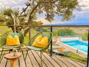 two chairs sitting on a deck next to a swimming pool at Neuve Romantique in Montbrun-des-Corbières
