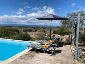 a patio with a table and an umbrella next to a swimming pool at Neuve Romantique in Montbrun-des-Corbières
