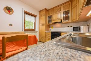 eine Küche mit einer Spüle und einer Arbeitsplatte in der Unterkunft Majon Fior de Bosch 1 in Campitello di Fassa