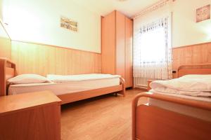 Zimmer mit 2 Betten und einem Fenster in der Unterkunft Majon Fior de Bosch 1 in Campitello di Fassa