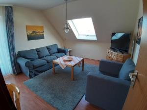 a living room with a blue couch and a table at Haus Strandgang, Whg 5 in Kellenhusen
