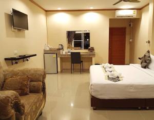 een hotelkamer met een bed en een bank bij 4 Palms Resort in Bang Sare