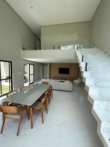 a dining room with a table and chairs and stairs at Casa em Guarajuba in Guarajuba