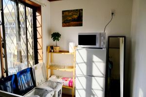 una cocina con un microondas encima de un refrigerador en Shinjuku/Kabukichō｜Super Busy Area｜Cozy House｜85㎡, en Tokio