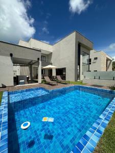 a swimming pool in front of a house at Casa em Guarajuba in Guarajuba