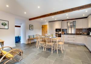 a kitchen and dining room with a table and chairs at Derwen in Llanfihangel-geneuʼr-glyn