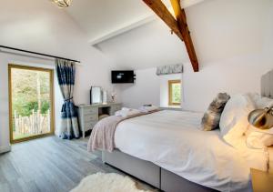 a bedroom with a large bed and a window at Derwen in Llanfihangel-geneuʼr-glyn