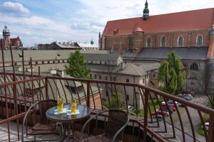 einen Balkon mit einem Tisch mit zwei Getränken darauf in der Unterkunft Hotel Secesja in Krakau