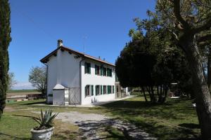 a white house with a tree in front of it at Casa di campagna Cà Teresa in Caorle