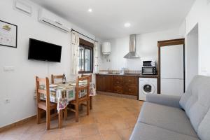 a living room with a table and a kitchen at Novobarrosa A in Chiclana de la Frontera