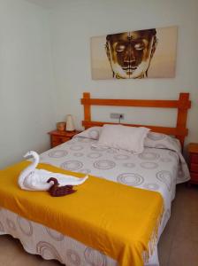 a bedroom with a bed with a swan on it at Luz de Mar. in Carboneras