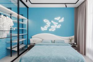 1 dormitorio con cama y pared azul en THE BEST APARTMENT ON THE SEASIDE IN ODESA! Luxury apartments in Arcadia, near seaside!, en Odessa