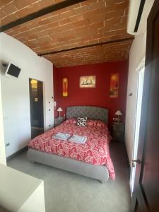 1 dormitorio con paredes rojas y 1 cama. en Bed&Wine, en Brisighella